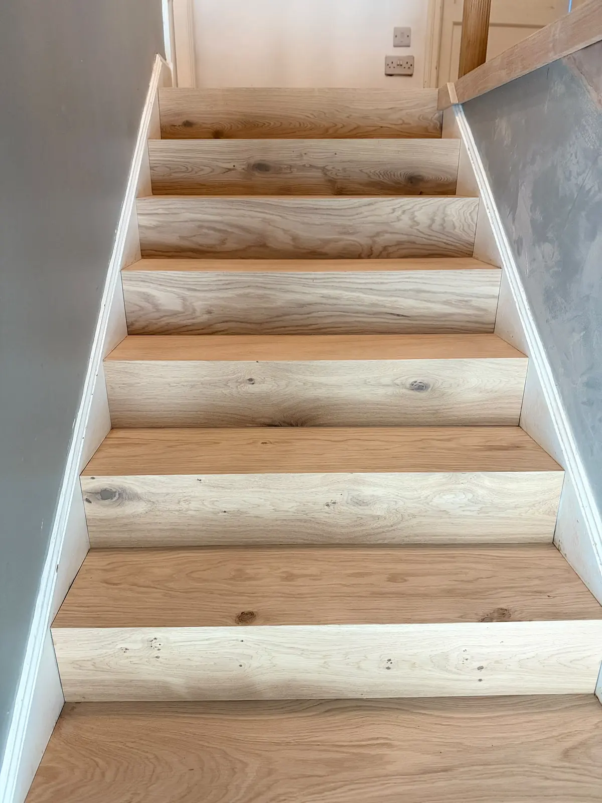 Oak-clad staircase with matching treads and risers, seen from the hallway