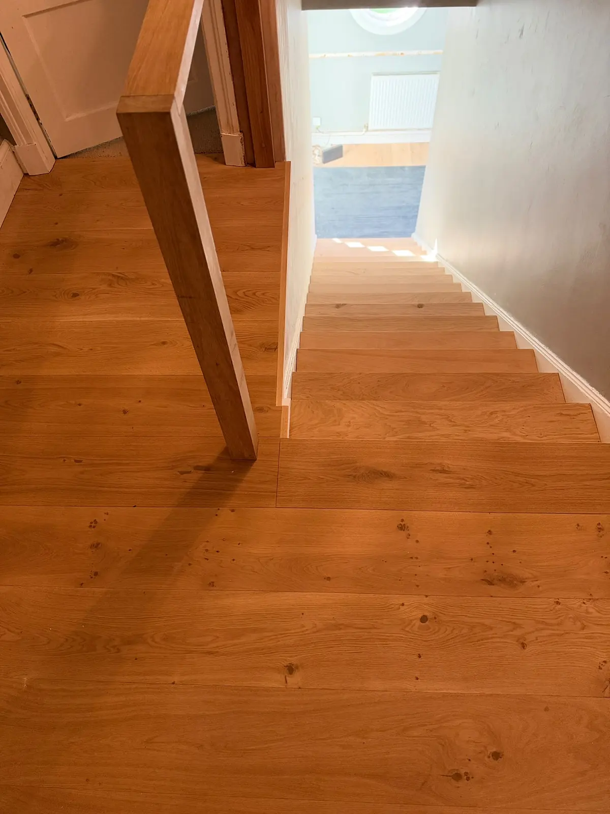 Oak landing floor with a bespoke profile covering the edge next to the banister