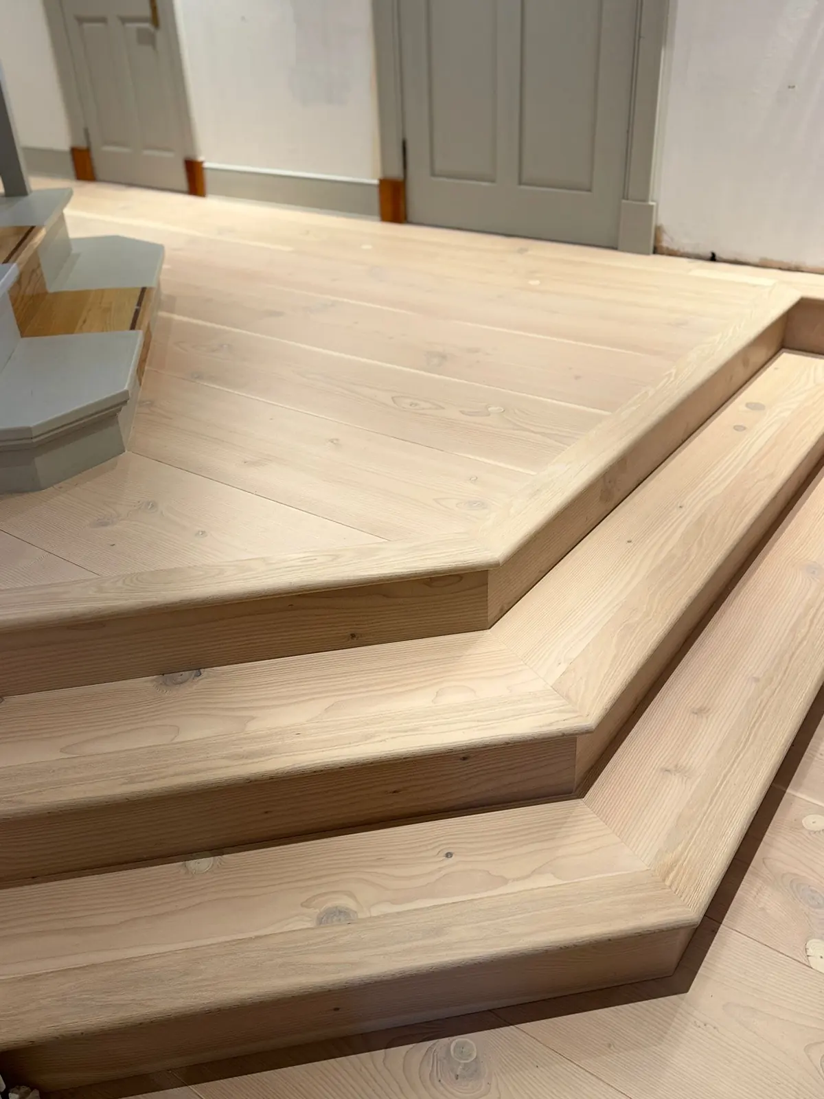 Angled steps clad in Douglas fir with bespoke mitred stair nosings