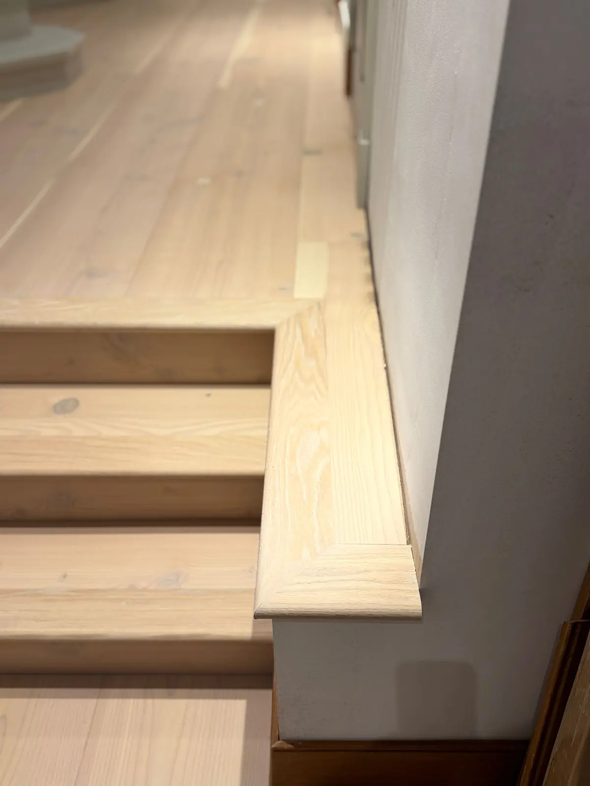 Bespoke Douglas fir stair nosing with a mitred return against the wall