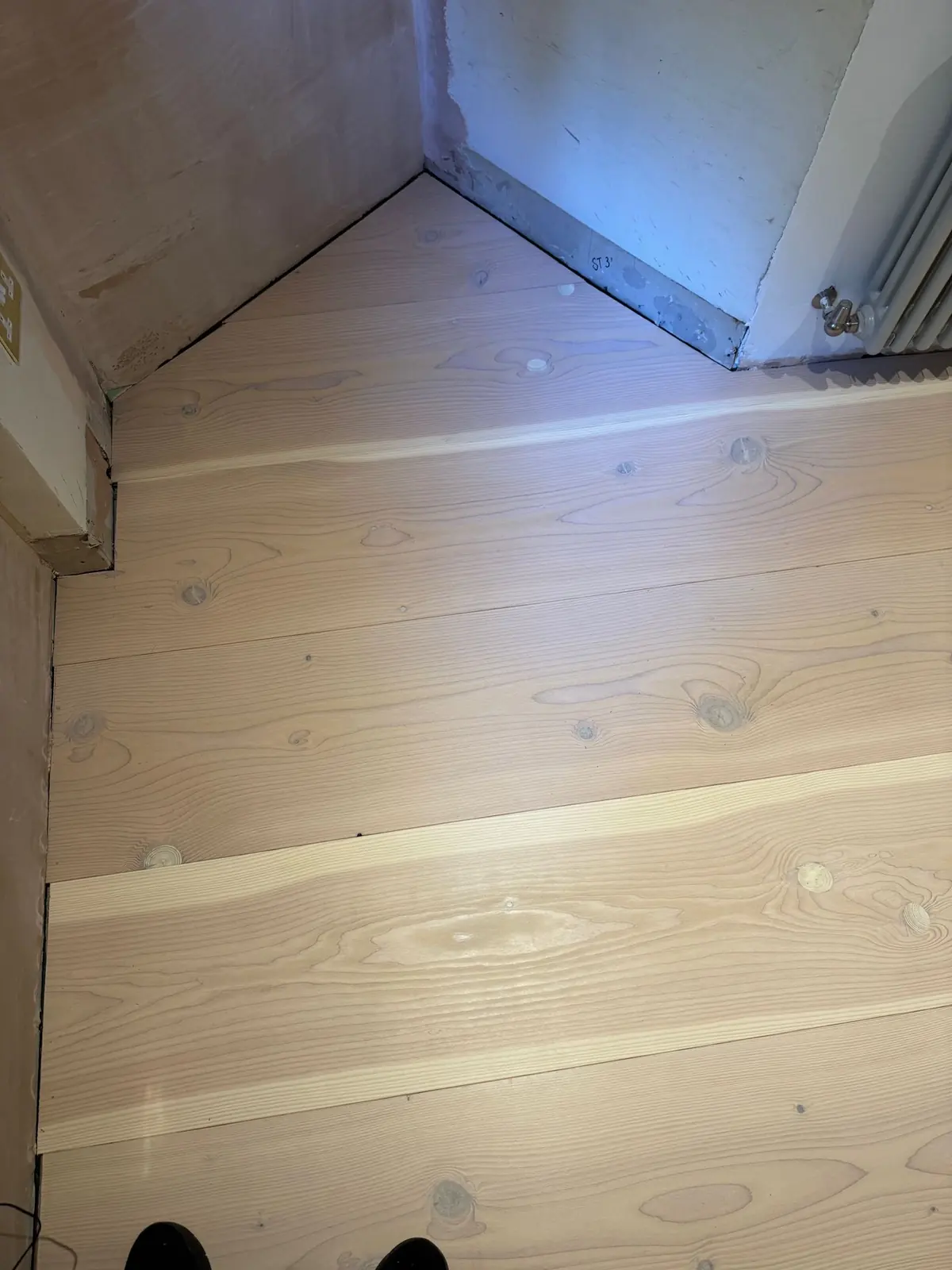 Douglas fir planks scribed to an angled bedroom wall
