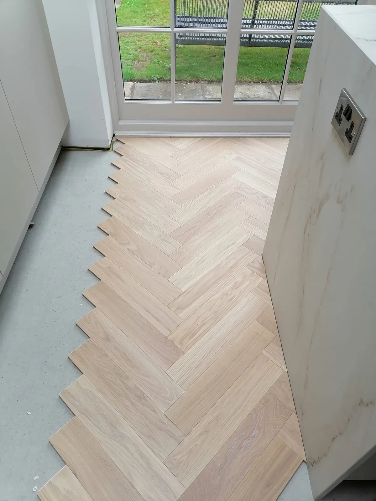 Herringbone parquet glued down up to the garden doors over underfloor heating