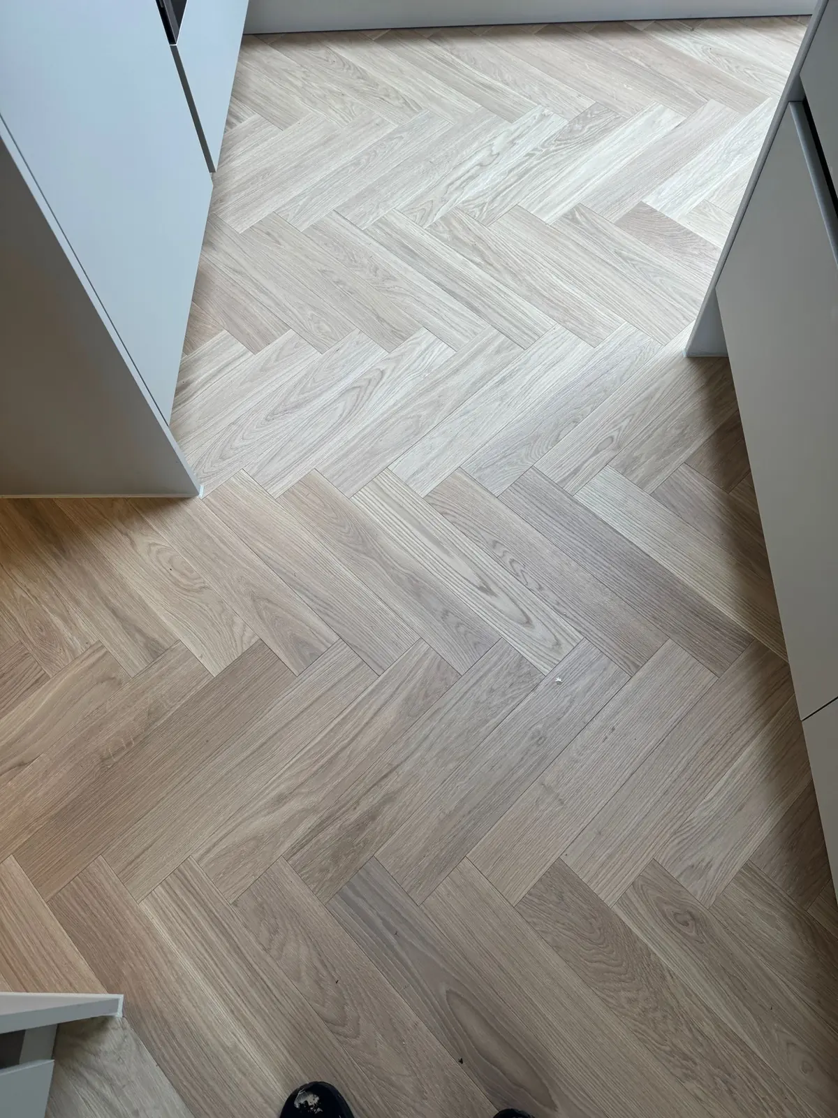 Herringbone parquet scribed to an angled kitchen panel