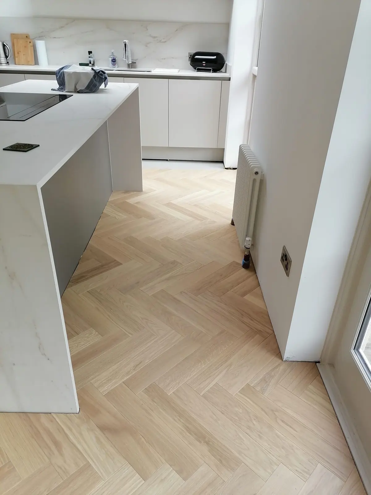 Ice Cream herringbone parquet around a marble kitchen island