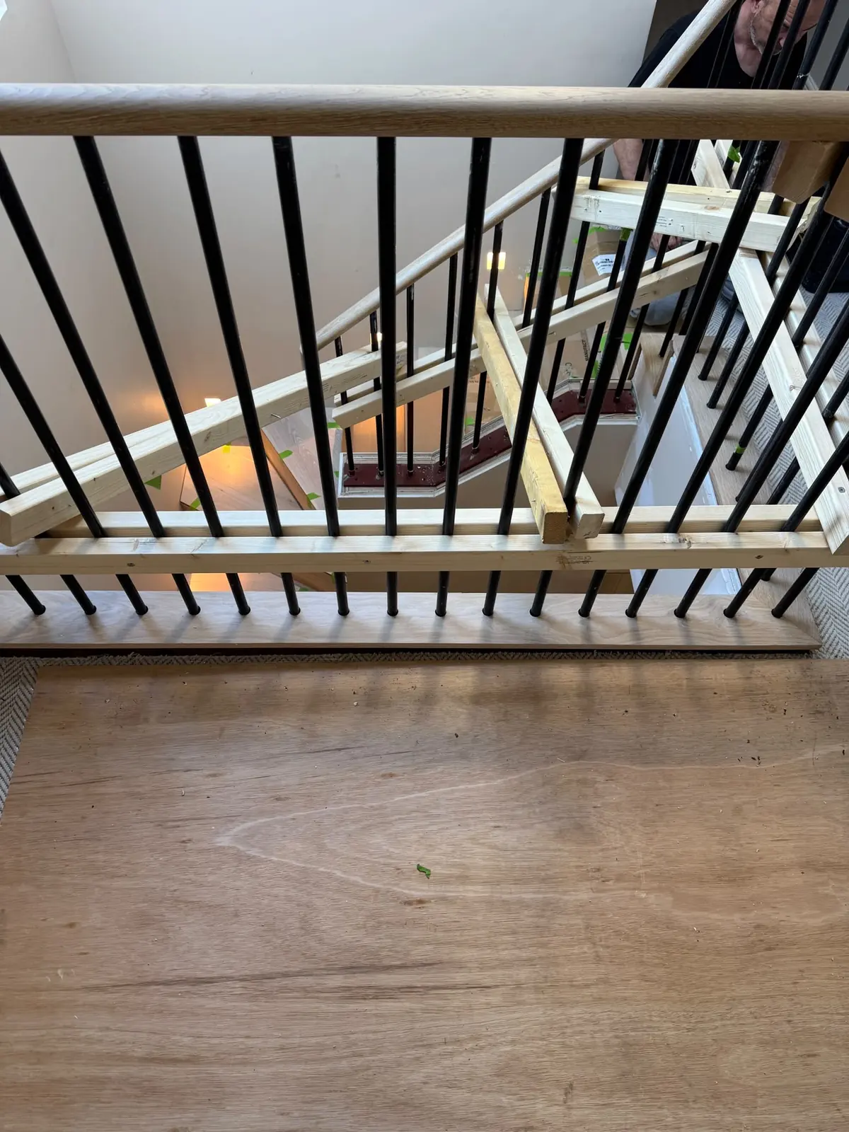 Metal-framed staircase landing with plywood base and temporary bracing after the old cladding was removed