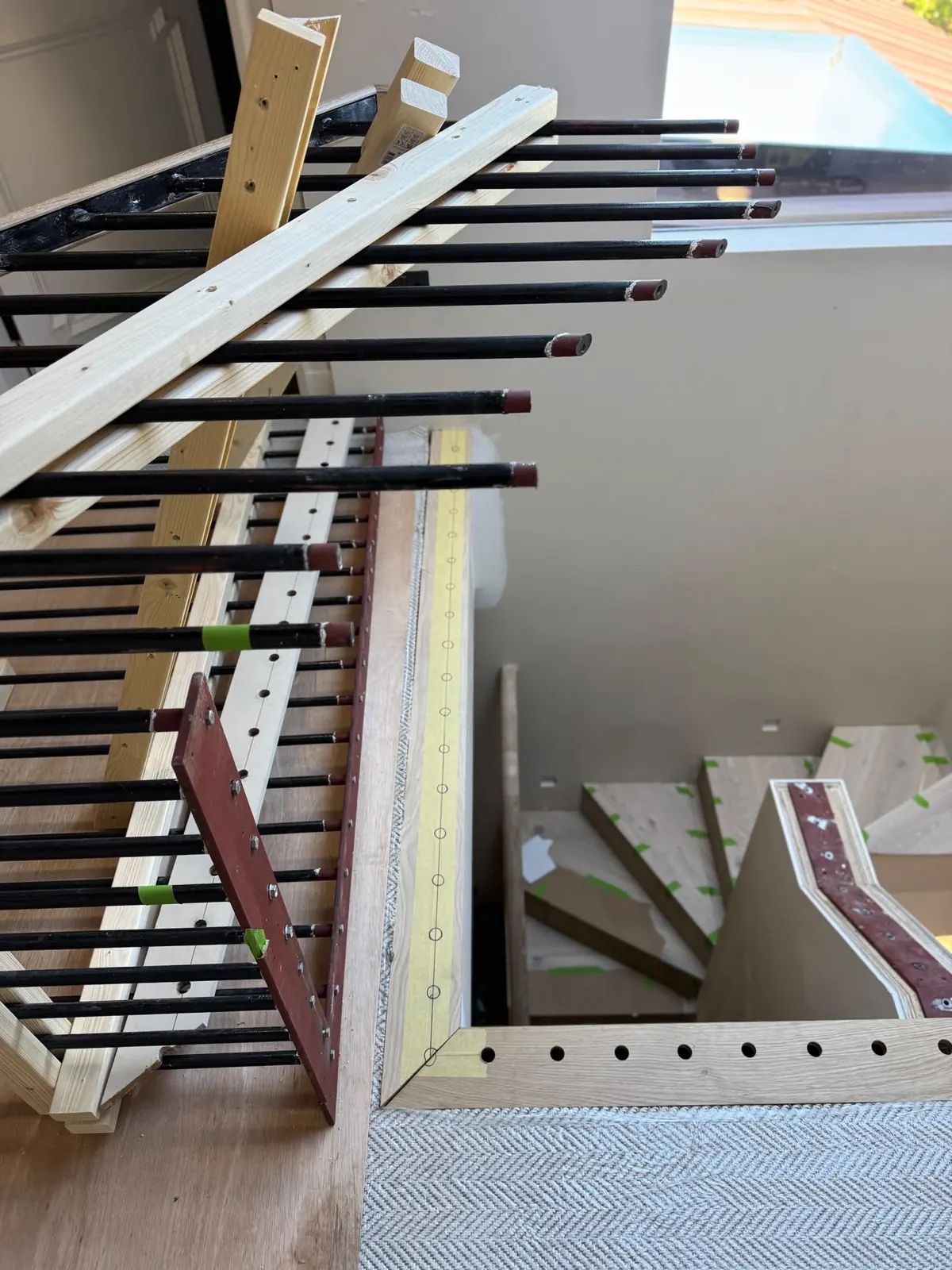 Metal spindles cut free from the staircase, with the new solid oak side bar marked out for drilling