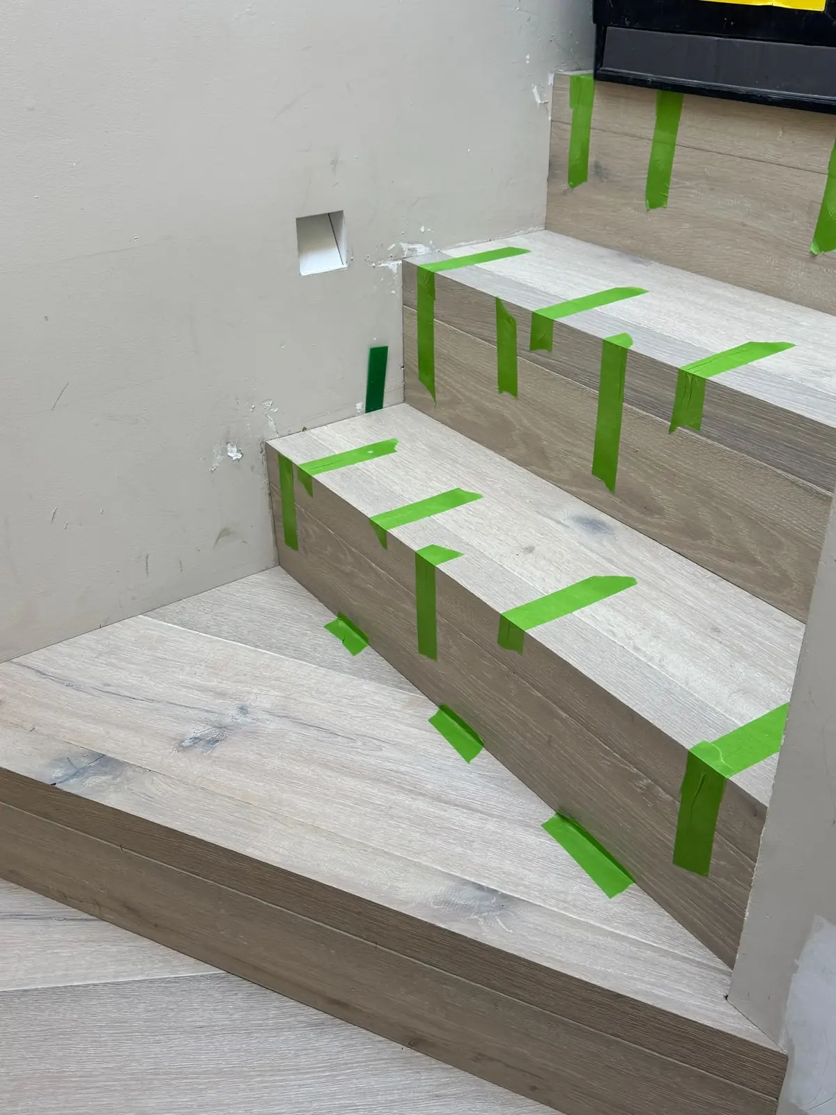 Oak winder treads taped while the adhesive cures