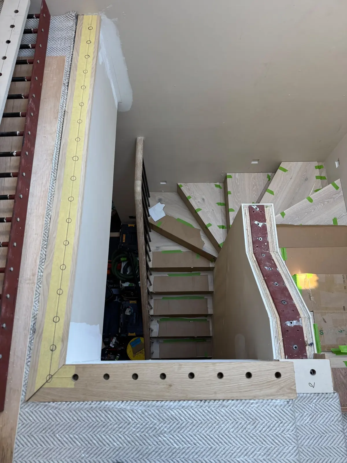Solid oak side bars drilled for metal spindles next to the steel stair stringer