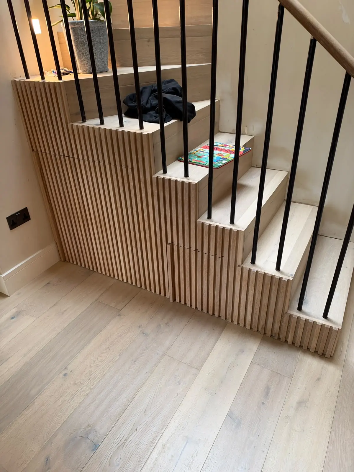 Bespoke solid oak slatted under-stairs storage with hidden doors in an Inverleith, Edinburgh home