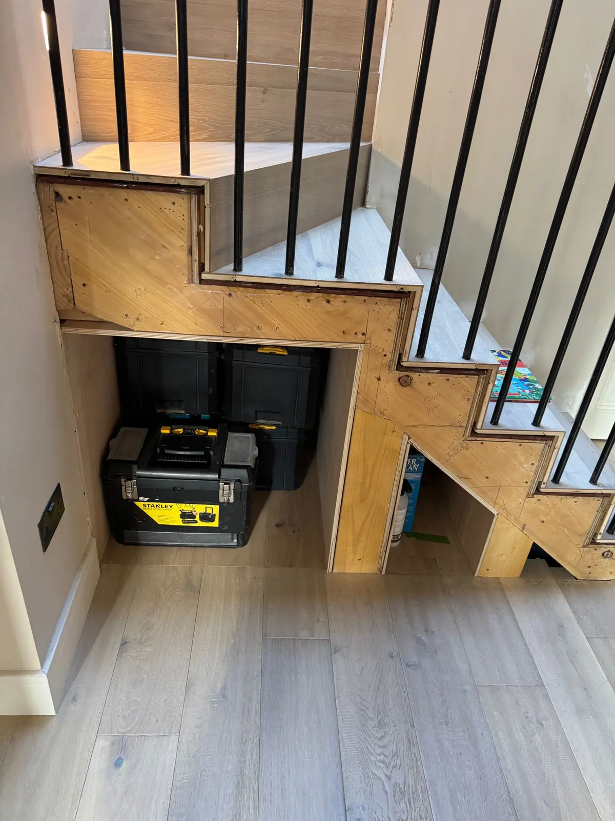 Under-stairs storage frame and doors before the oak slat cladding