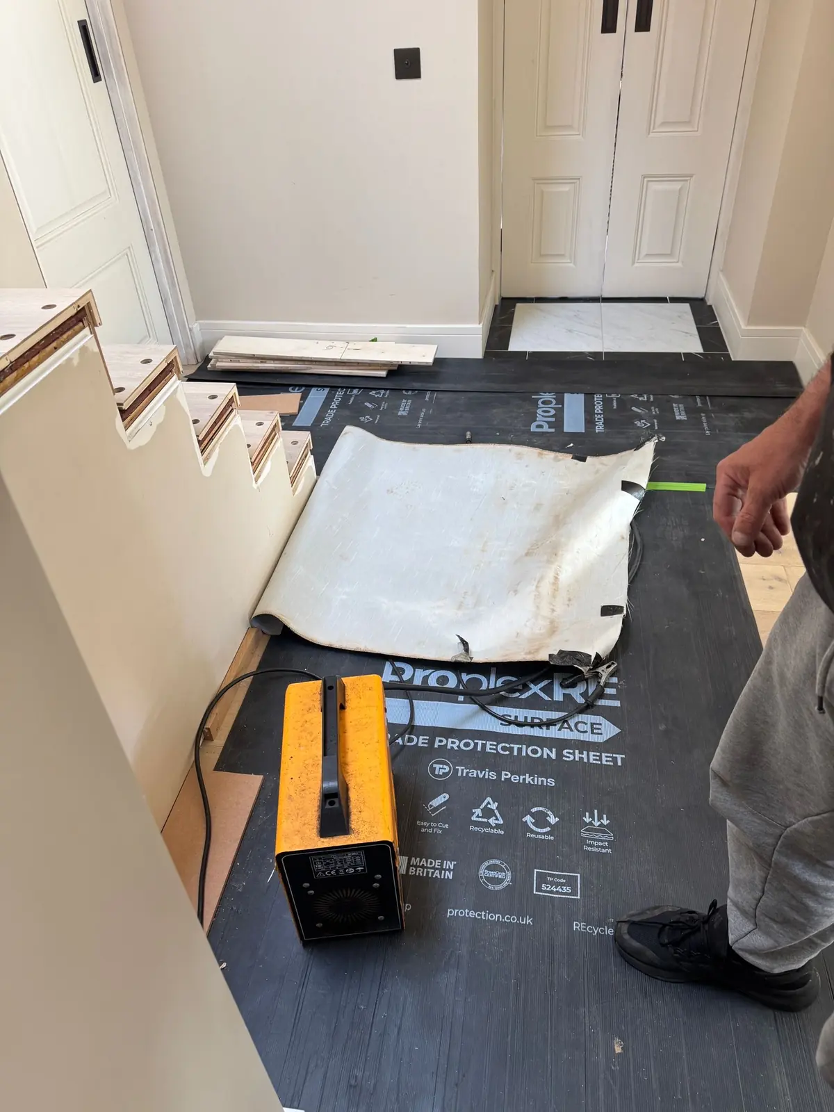 Welding machine on protected hallway floor, used to re-weld the metal spindles to the staircase