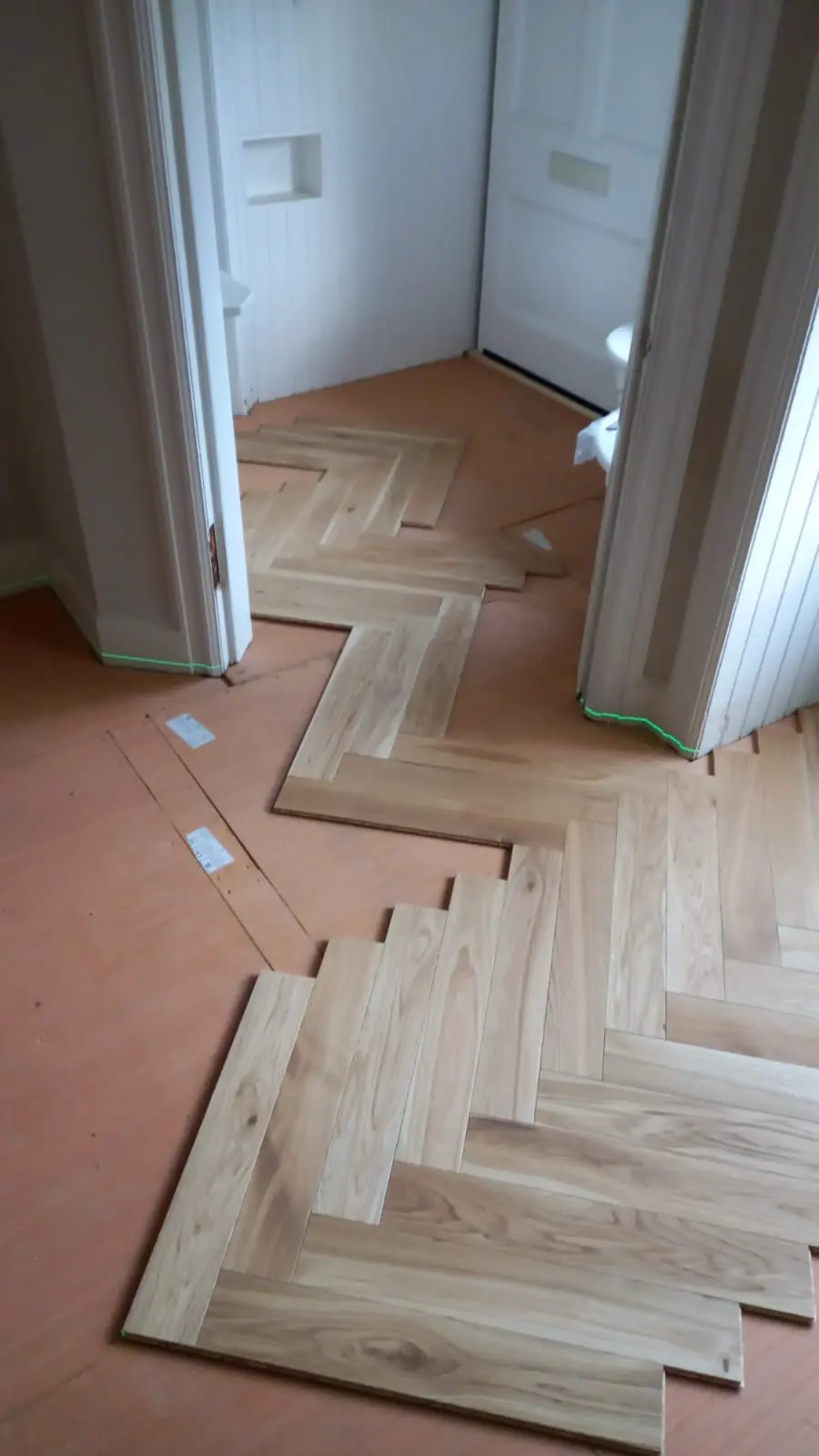 Herringbone blocks dry-laid to the laser line through the hallway doorways