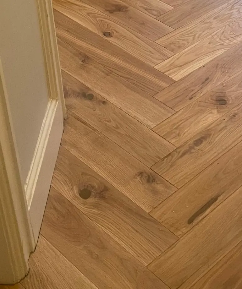 Herringbone parquet continuing through a hallway doorway