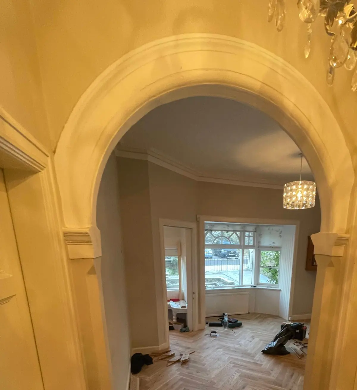 Invisible oak herringbone parquet seen through the hallway arch into the living room of a Braid Hills house in Edinburgh
