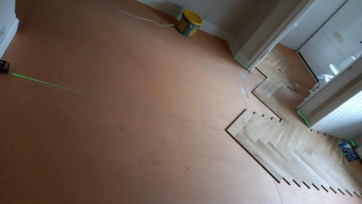 Laser line set out on a 6mm plywood subfloor before herringbone parquet installation