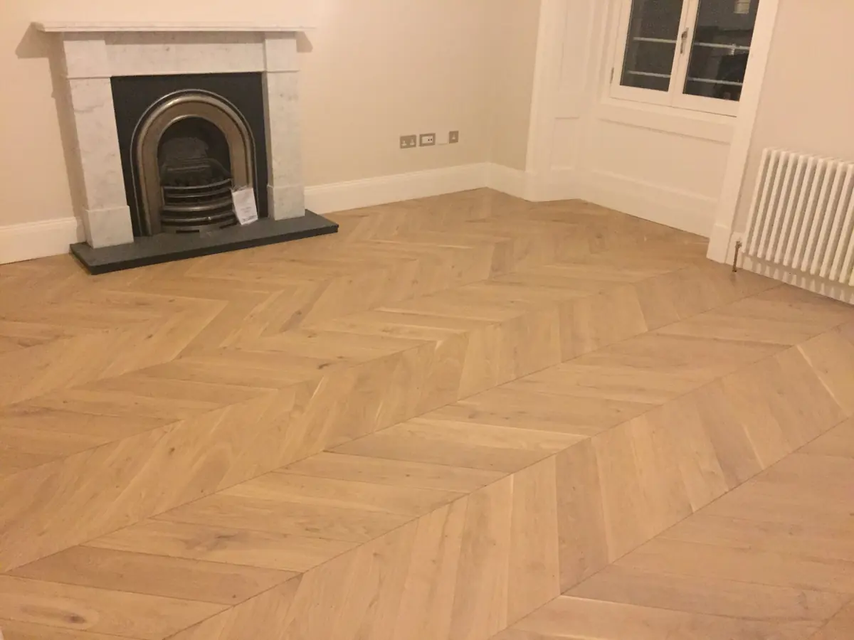 Chevron parquet in a hallway leading to bedroom doors
