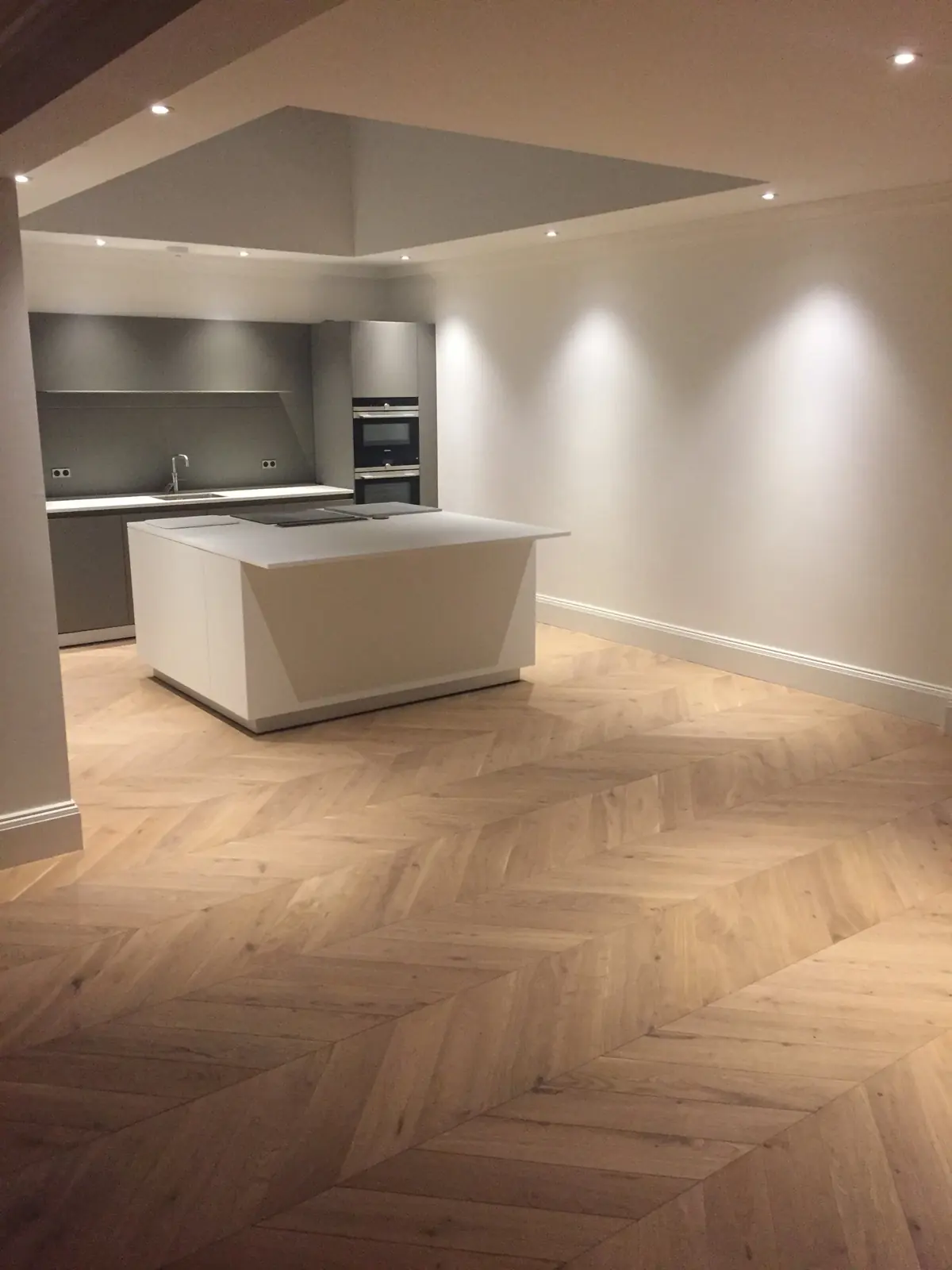 Light Oak chevron parquet running from the kitchen island into the living area