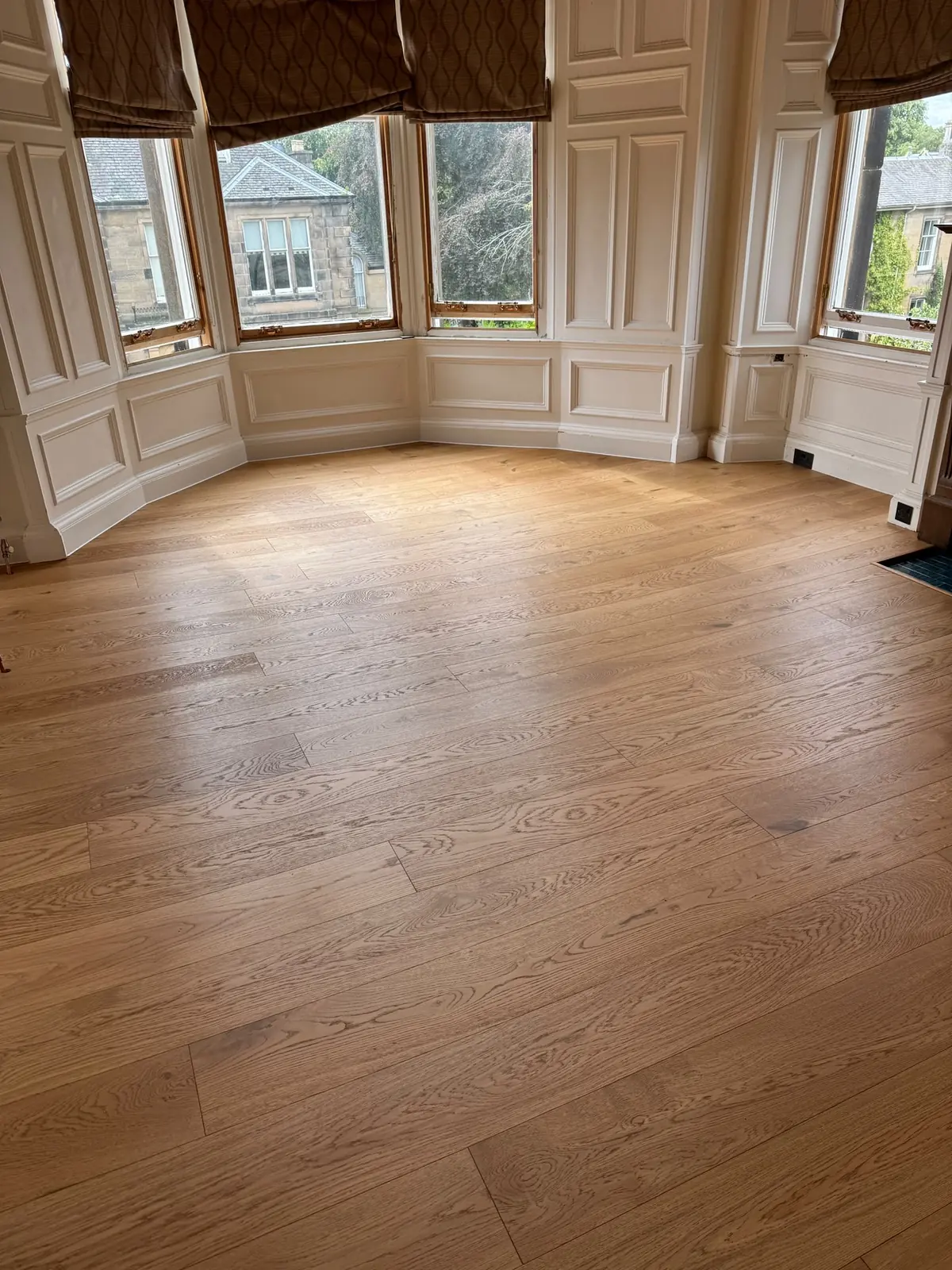 220mm natural grade oak planks in a room with a panelled bay window