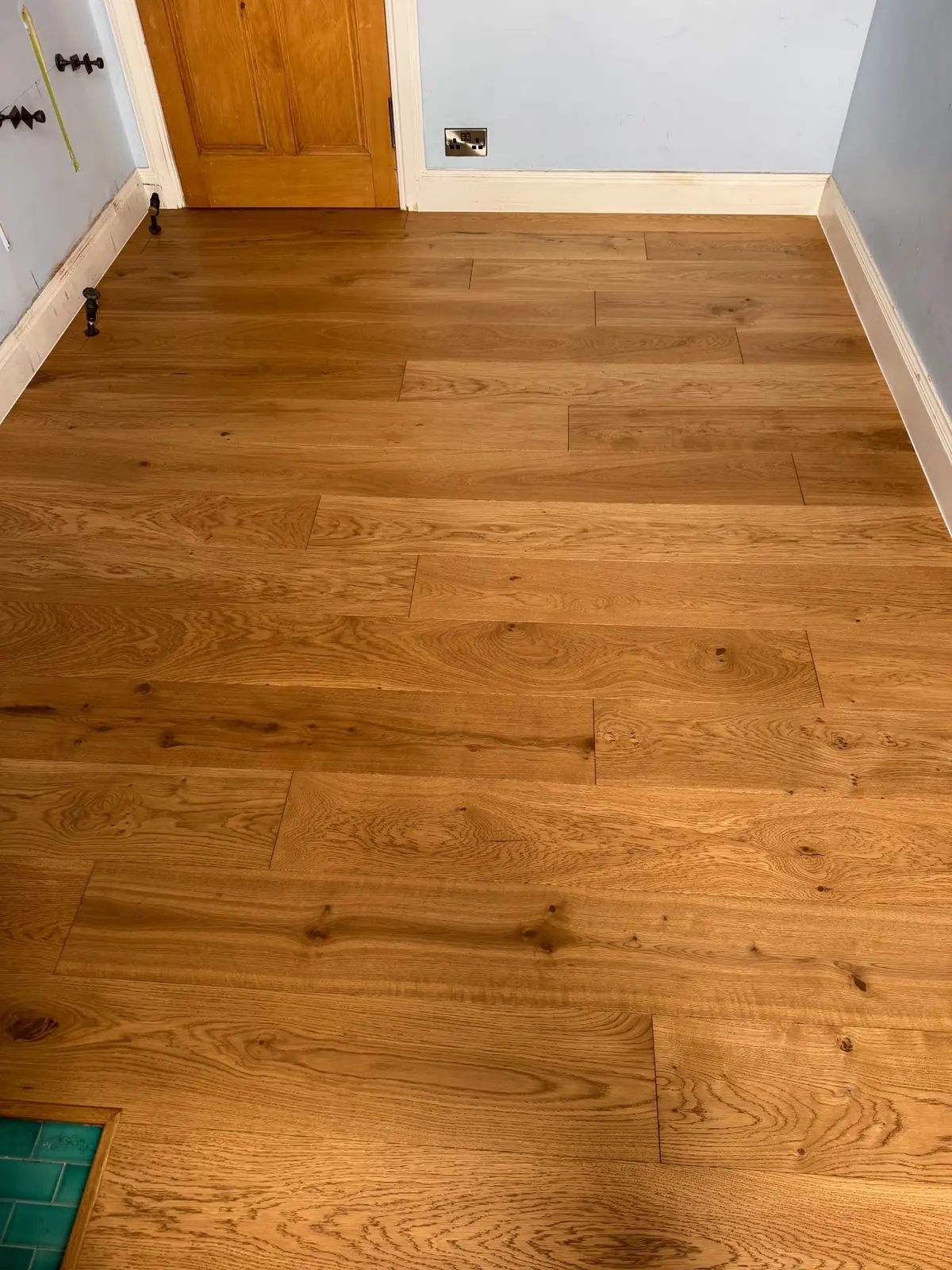 Oak floor fitted to a tiled fireplace hearth in a small bedroom