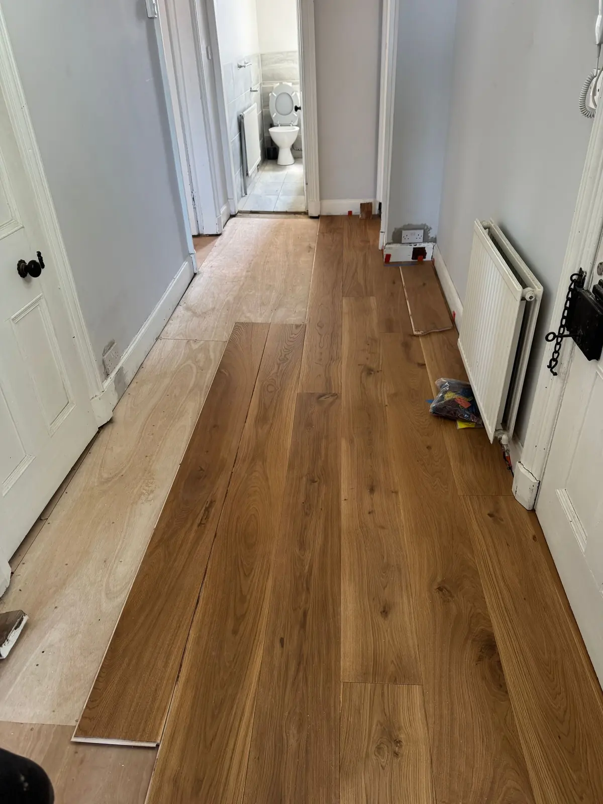 9mm plywood overlay and the first oak planks being laid in the hallway