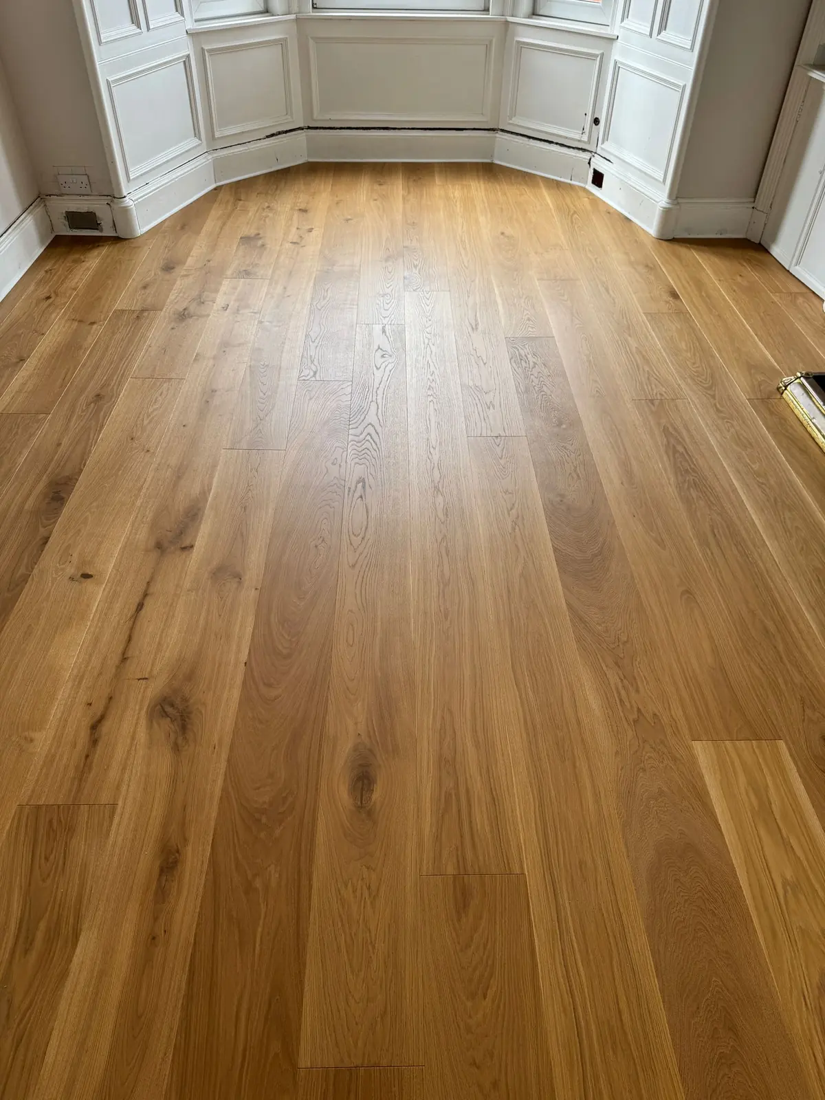 Natural grade oak planks running towards a bay window