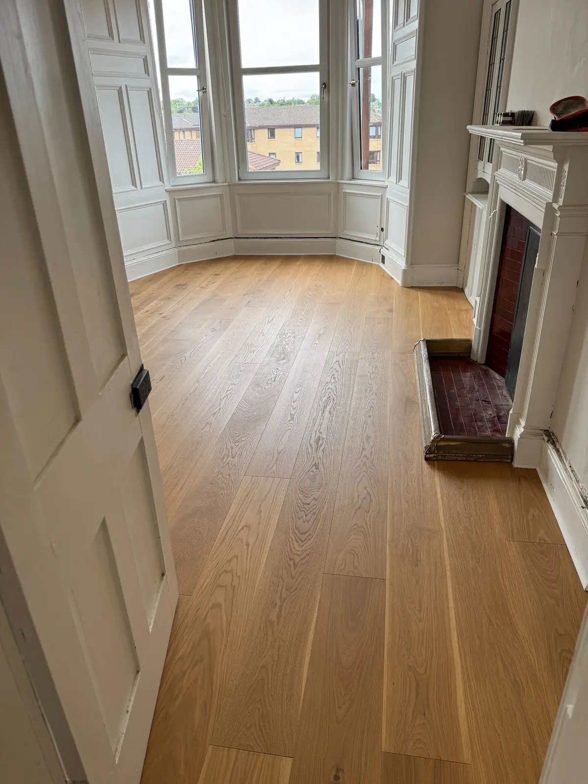No. 44 engineered oak flooring in a living room with a panelled bay window and fireplace in an Edinburgh flat