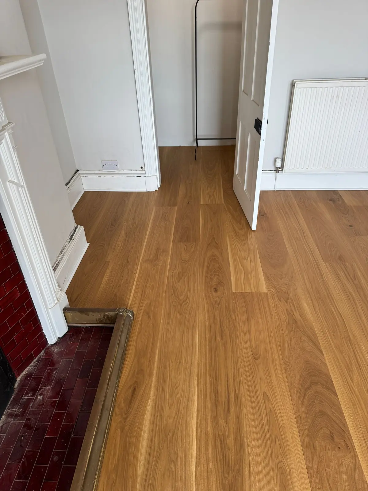 Oak floor fitted around a tiled fireplace hearth