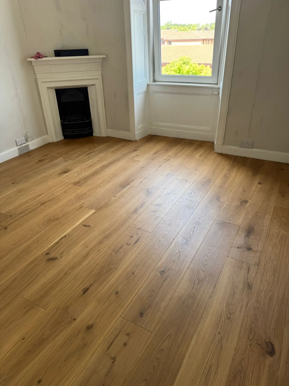 Oak flooring in a bedroom with a corner fireplace