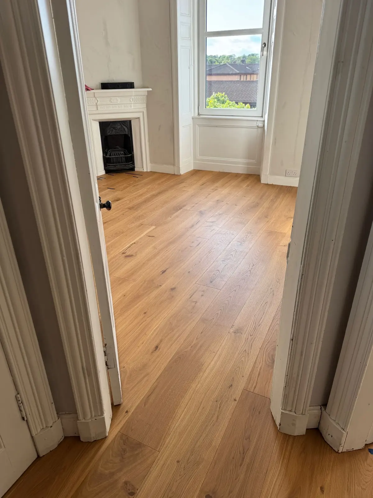 Oak flooring seen through a bedroom doorway