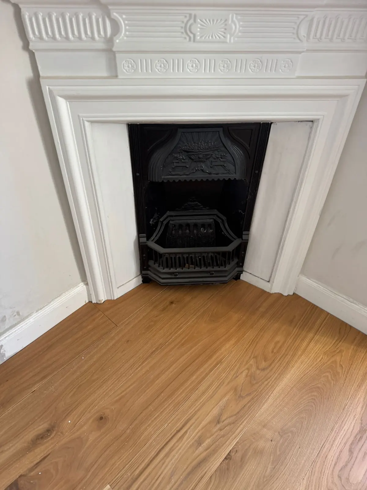 Oak planks fitted neatly to a cast iron corner fireplace