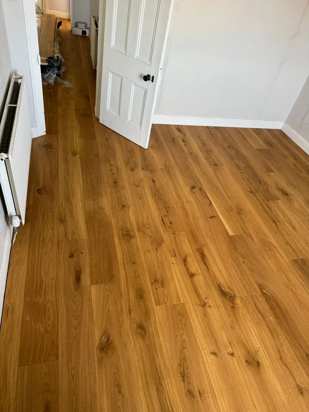 Oak planks running from a bedroom into the hallway