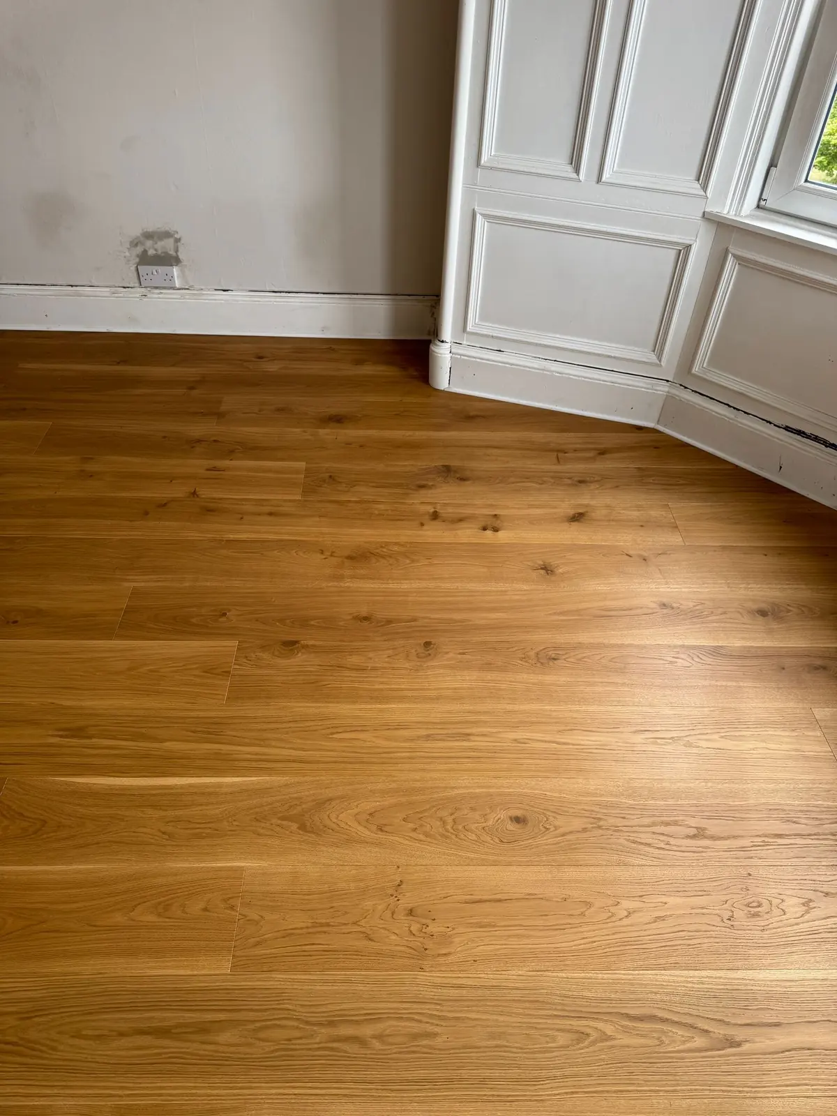 Oak planks scribed to the curved skirting of a bay window