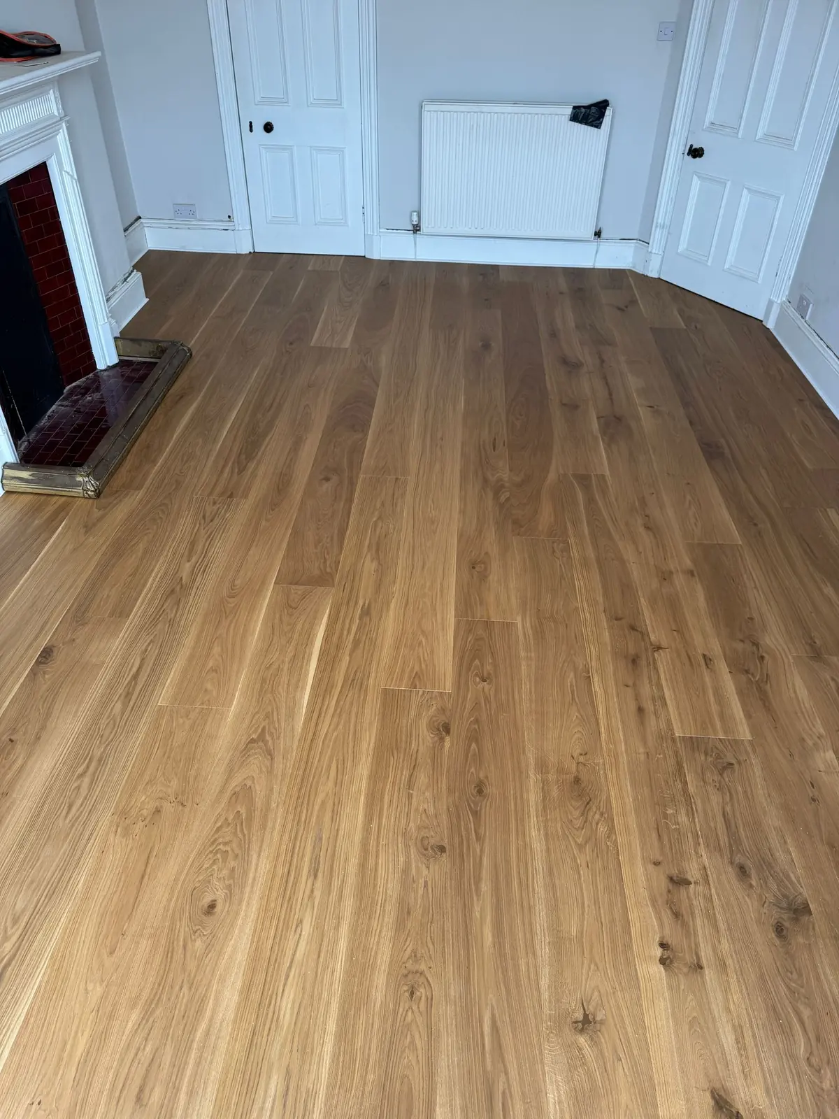 Wide oak planks in a dining room with a fireplace