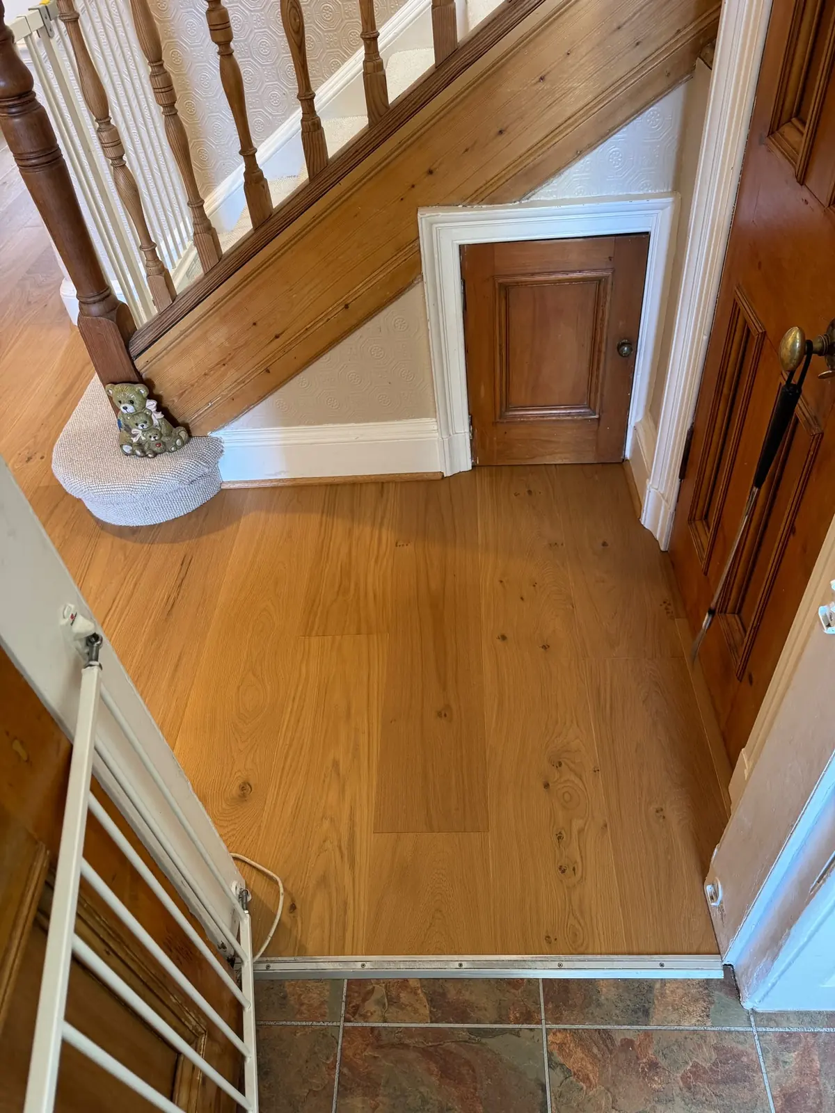 Oak floor meeting slate tiles at a doorway with a transition profile