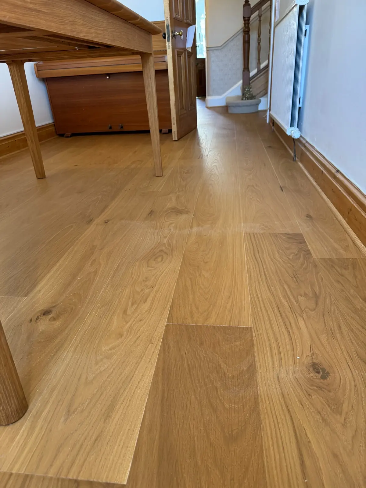 Oak flooring running from the dining room into the hallway