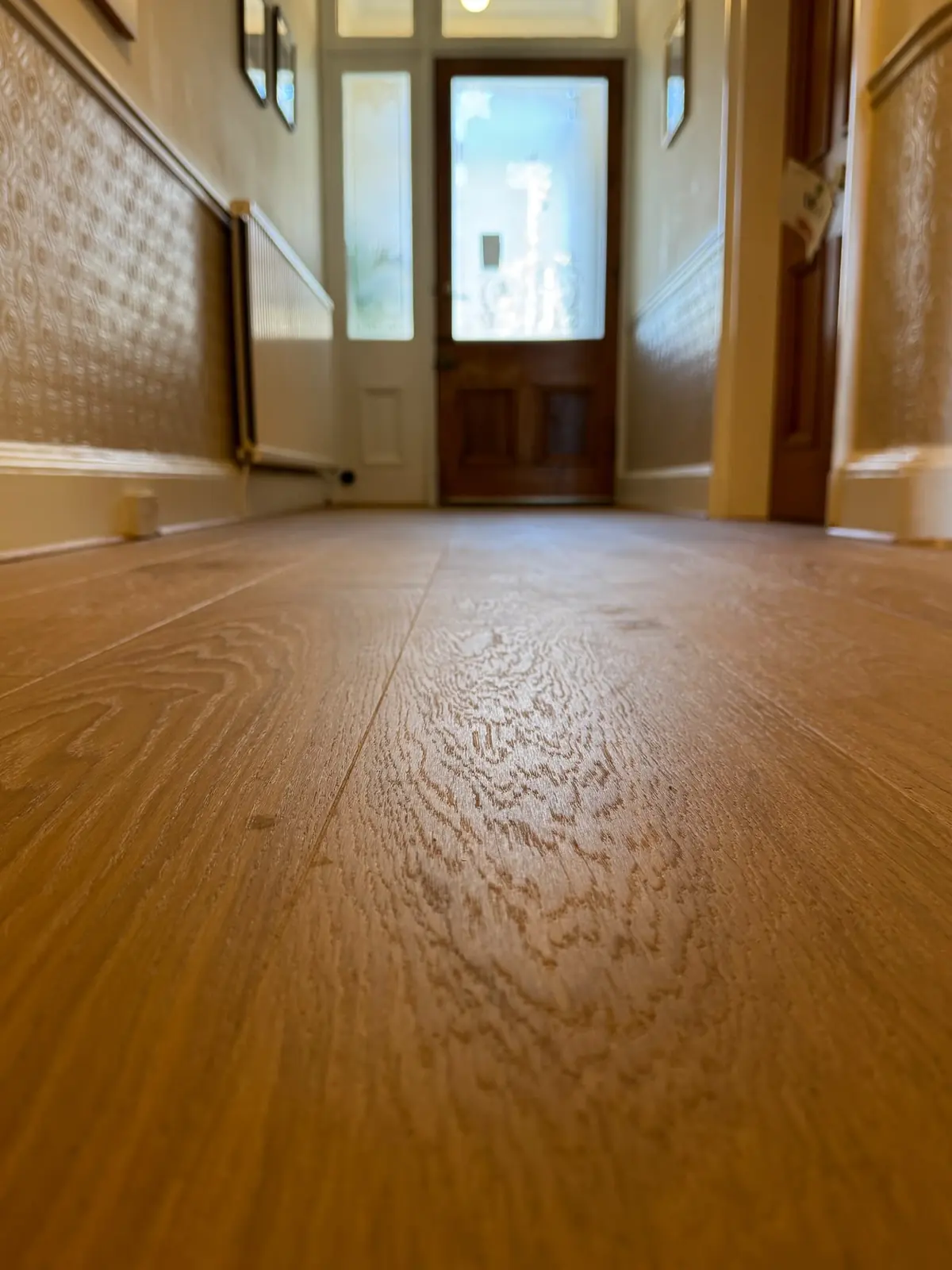 Close-up of the oak grain running down the hallway to the front door
