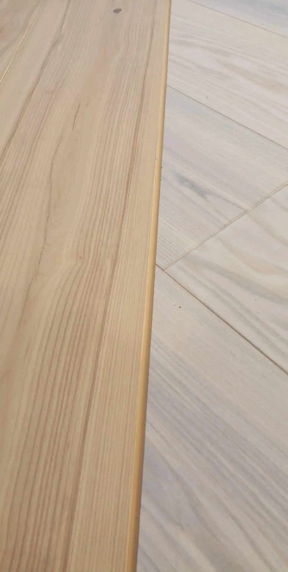 Close-up of the transition between Ash Natural and White Ash engineered flooring