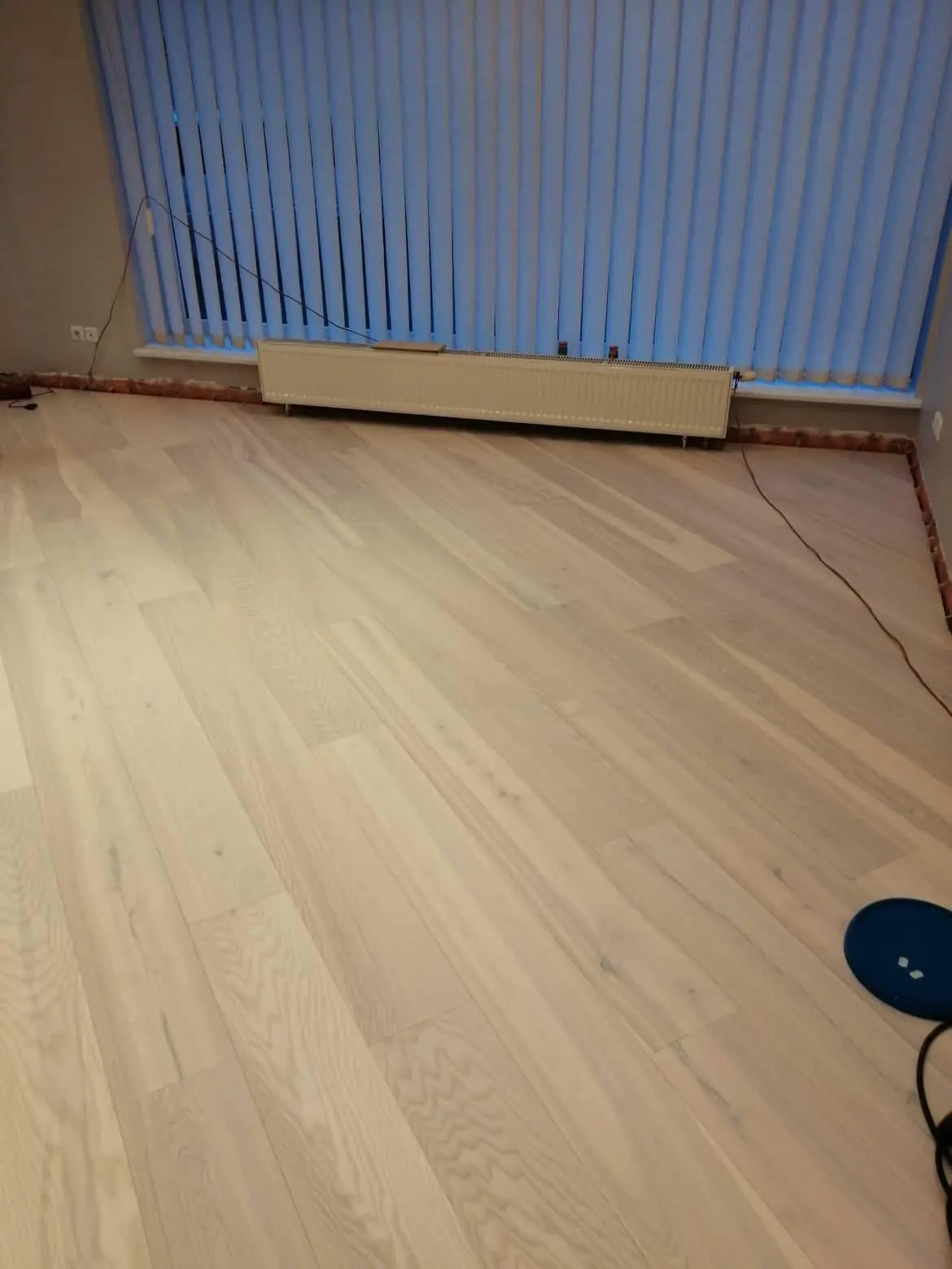 White oiled engineered ash wide planks in a Vilnius office in front of the windows