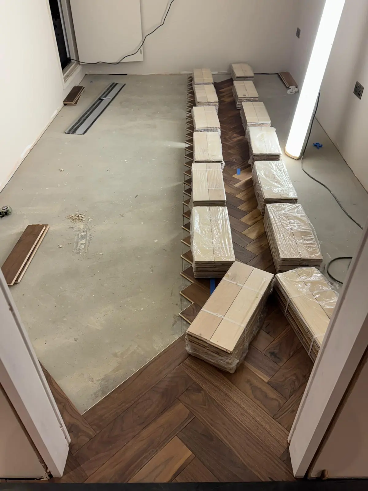 American walnut herringbone blocks dry-laid and taped to check the pattern before gluing