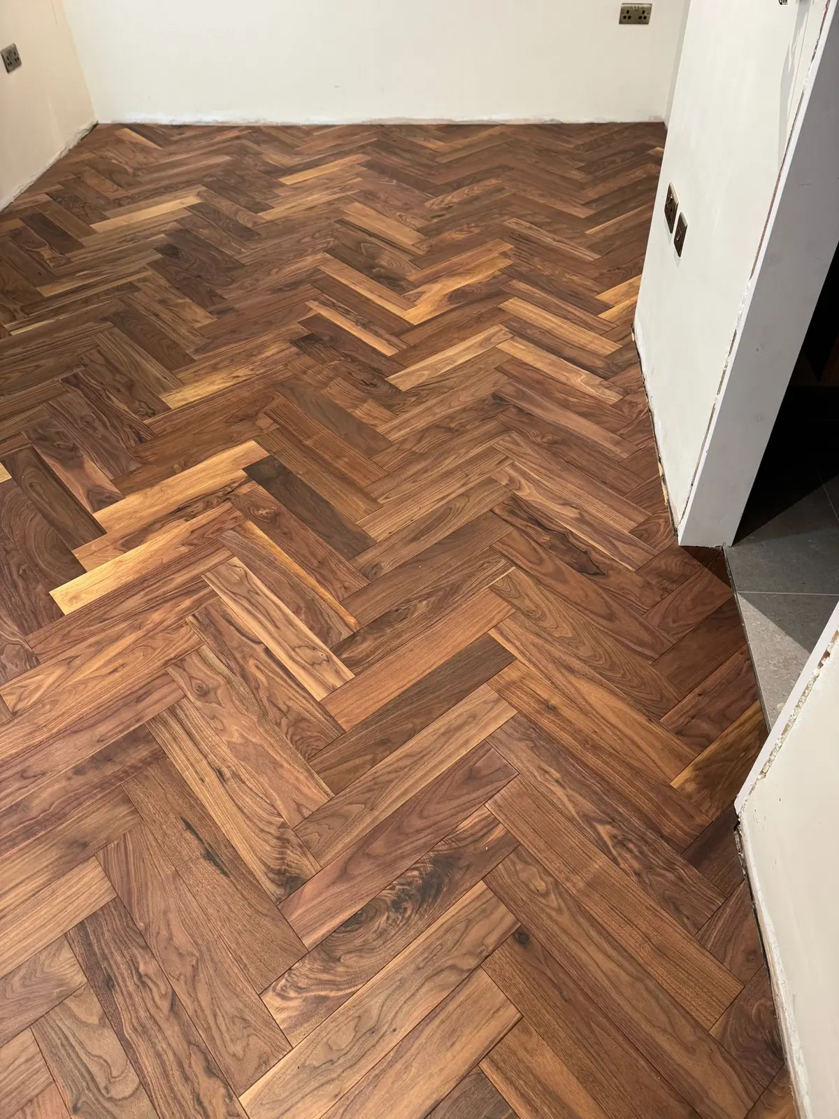 Walnut herringbone parquet in a bedroom by the ensuite doorway